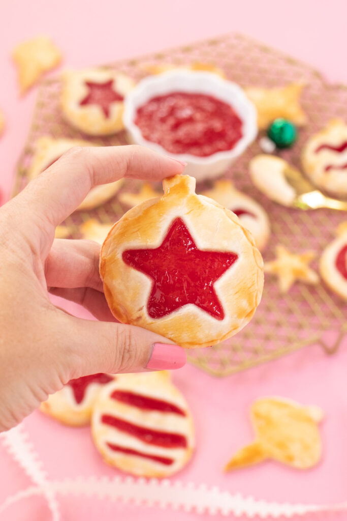 Ornament Pies // Christmas Hand Pies // Cut pie dough into ornament shapes with cut-out details for making cute mini Christmas pies! Fill with colorful cherry pie filling for a great holiday treat or after-dinner Christmas dessert #christmasrecipe #pie #handpies #christmasdessert #pierecipe #cookiecutters #diyornaments