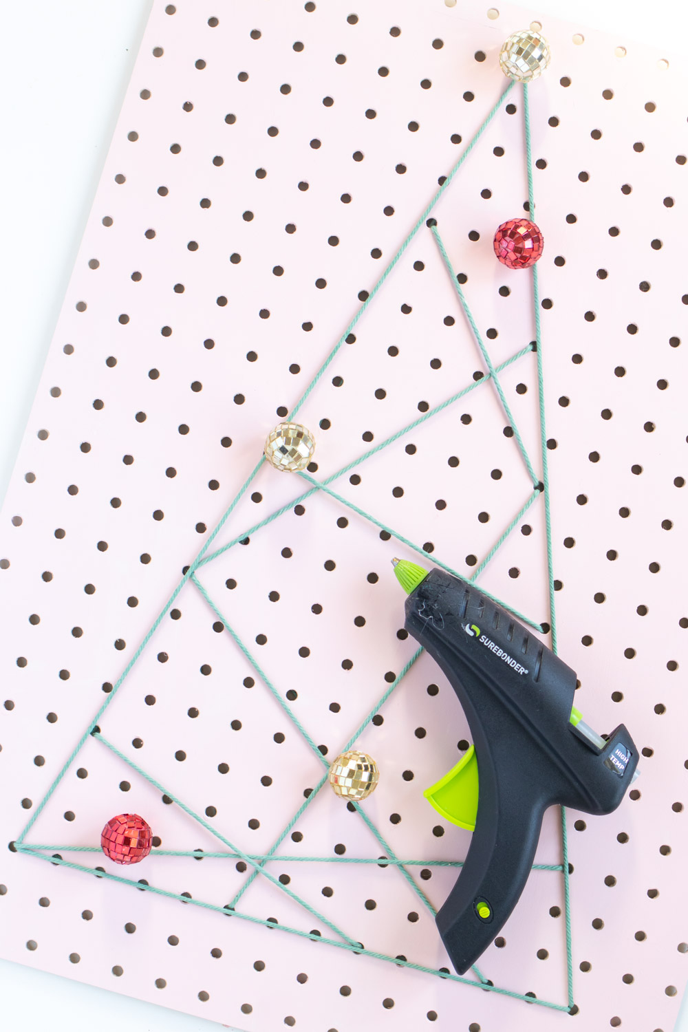 DIY Holiday Pegboard Card Holder // Turn a slab of pegboard into a fun Christmas tree card display inspired by string art! Display your holiday cards in a unique way with this DIY Christmas decor idea #christmasdiy #christmascard #christmasdecor #christmasstorage #pegboard #papercrafts #stringart #holidaystorage #cardstorage